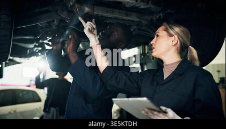 Mechanic, workshop and people on tablet with car for inspection, report and vehicle diagnostics. Team, garage and woman with tech for motor repair Stock Photo