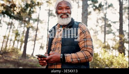 Hiking, phone and portrait of senior man in forest for wellness, fresh air and online direction. Travel, happy and elderly African person on nature Stock Photo