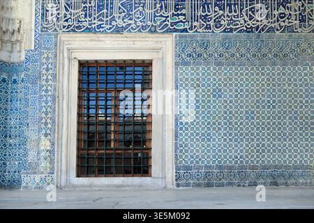 Iznik ceramic tiles with Arabic calligraphy and iron window grille in Ottoman mosque, Istanbul, Turkey Stock Photo