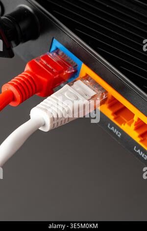 Connecting ethernet cables to a network router in a home office setup Stock Photo