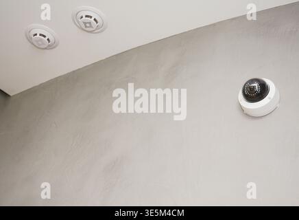 Security  CCTV camera is mounted on the room wall with Fire alarm system, Fire detection and Smoke Alarm. Stock Photo