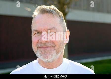 Portrait of a mature man with beard standing outdoors in warm natural sunlight. Stock Photo