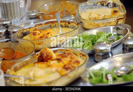Primary school pupils having lunch with their peers and techers in a UK school. Stock Photo
