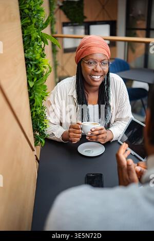 Woman smiling having coffee meeting a man in cafe Stock Photo