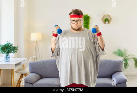 Overweight man lifting dumbbells for fitness workout at home, doing exercises Stock Photo