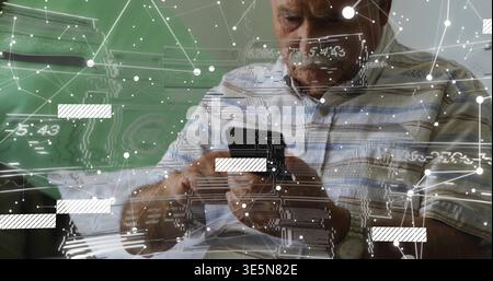 Holding smartphone, senior man in plaid shirt studying papers at home with AR overlay, wristwatch Stock Photo