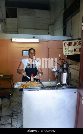 A Cuban woman preparing Churros in a small shop on Simón Bolívar Avenue in Havana, Cuba. Stock Photo