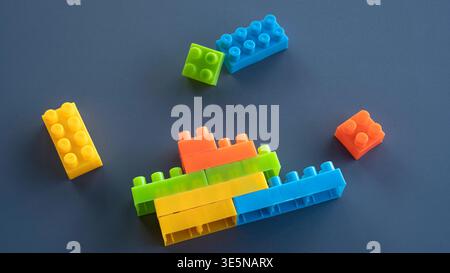Colorful Plastic Building Blocks Stacked in Creative Formation on Dark Background Stock Photo