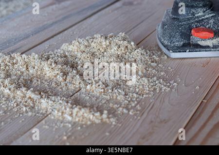 Electric sander with wood shavings on wooden surface carpentry woodworking process and tool concept Stock Photo