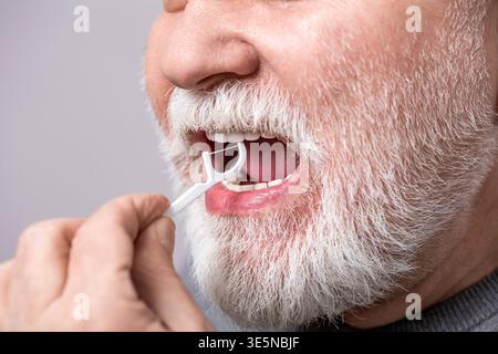 Dental floss and pick. Oral hygiene and health care, smiling man use dental floss white healthy teeth. Flossing teeth, man flossing teeth dental floss Stock Photo