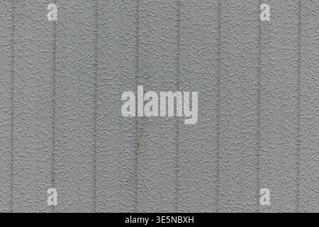 Close up of a light gray wall surface with fine textured relief and vertical lines. Stock Photo