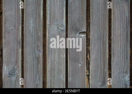 Close up of old wooden boards with visible gaps and rough surface. Natural aged texture with gray green tones, knots, and worn wooden structure. Stock Photo