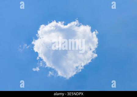 Cottony white cumulus cloud forming a perfect heart shape in clear blue sky Stock Photo