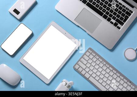 Tablet computer with different modern gadgets on blue background Stock Photo