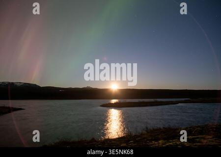 Aurora borealis moonrise over Thingvellir lake Iceland Stock Photo