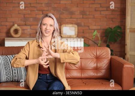 Mature mute woman using sign language at home Stock Photo