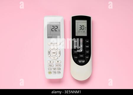 Air conditioner remote controls on pink background Stock Photo