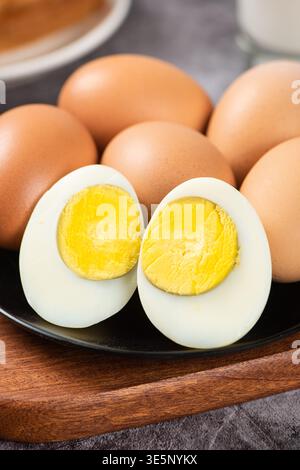 Cooked brown eggs on a plate, cut in half showing bright yellow yolk Stock Photo