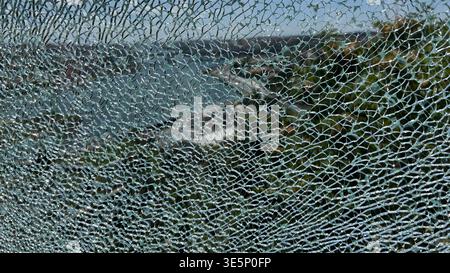 Shattered tempered glass window texture background, broken safety glass pattern background. Stock Photo