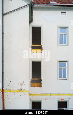 Residential building facade with window openings during renovation, construction site, urban development, architecture transformation and repair works Stock Photo