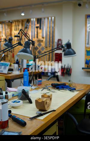 Workbench inside workshop filled with various tools, equipment, and materials, creating a busy environment for engineering, tinkering, and Stock Photo