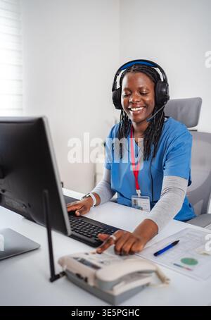 African American female nurse wearing headset doing telehealth consultation Stock Photo