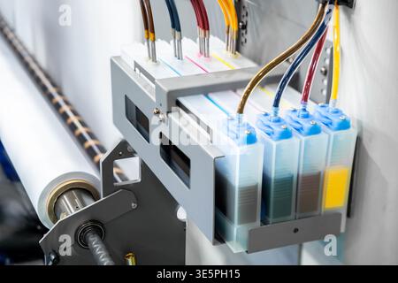 Color CMYK ink tank of a large printer machine in factory for digital printing business. Stock Photo