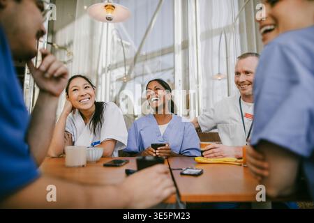 Happy team of healthcare workers enjoying coffee break in hospital cafeteria Stock Photo