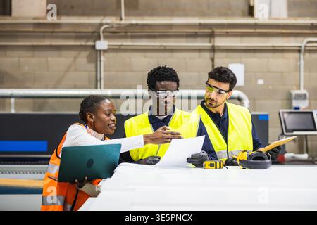 Diverse industrial workers collaborating on engineering plans Stock Photo