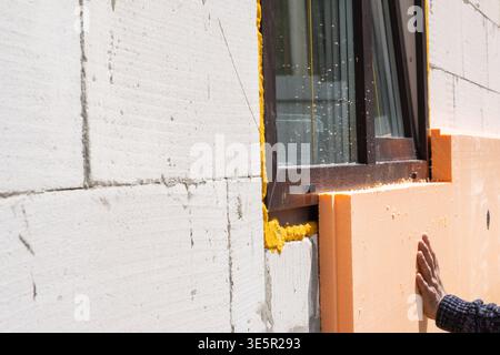 Foam board insulation attached to building wall, thermal upgrade, facade energy saving, modern cladding, installation process, construction at site, m Stock Photo