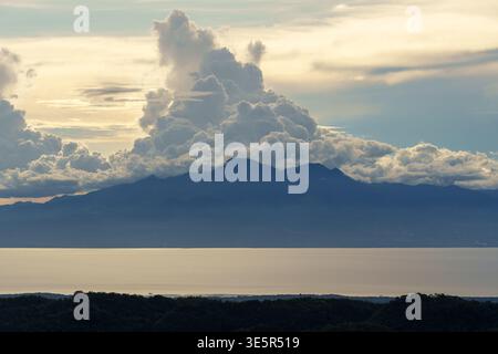 Mount Bandilaan, Siquijor, Philippines – April 12, 2025: A distant view shows the silhouette of Negros Island across the sea beneath towering clouds. Stock Photo