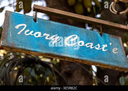 Hand-painted rustic sign with Ivory Coast text in a street of Kannur, South India Stock Photo