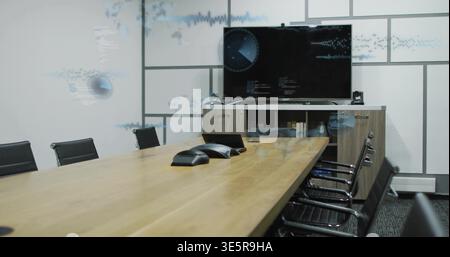 Framing long wooden conference table stretching toward screen in meeting room, with speakerphones Stock Photo