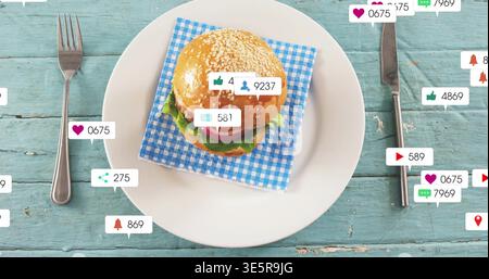 Displaying sesame hamburger on plate on turquoise table, gingham napkin and social bubbles Stock Photo