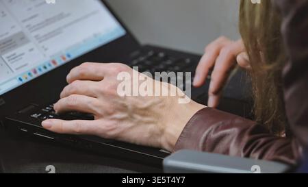 Person typing on a laptop computer, working online in Moscow Stock Photo
