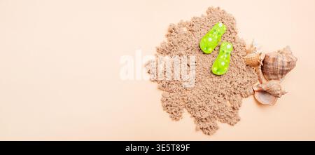 Panoramic Image Of Vibrant Green Sandals Resting On Broad Sand With Shells And Empty Area For Text Stock Photo
