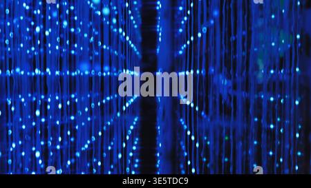 Data stream flowing through a network of blue light technology in an immersive art exhibition Stock Photo