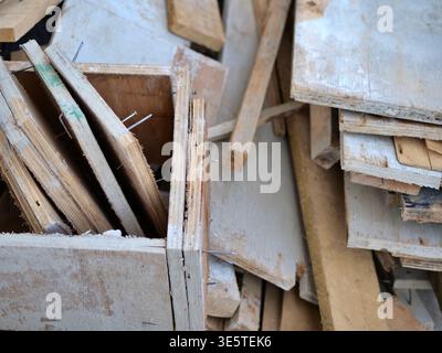 Close-up of a dark grey tiled floor covered in white plaster dust and debris, industrial renovation  scene showing messy cleanup after wall demolition Stock Photo
