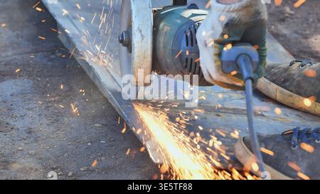 Worker using angle grinder cutting metal with sparks flying in Moscow Stock Photo