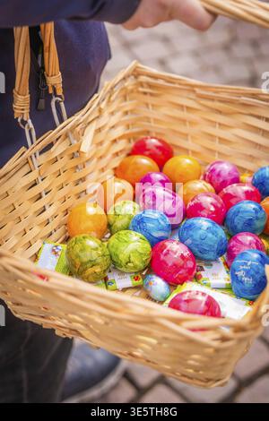 Woven basket filled with colorful Easter eggs is carried, Easter campaign, Sindelfingen, Boeblingen district, Germany Stock Photo