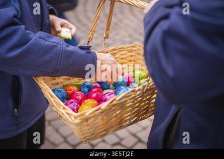 Colourful Easter eggs in a basket are viewed by two people, Easter campaign, Sindelfingen, Boeblingen district, Germany Stock Photo