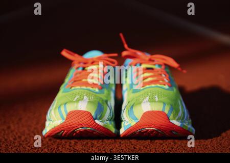 Running shoes on stadium track, Pair of sport sneakers for triathlon training Stock Photo