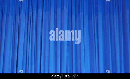 Vibrant blue stage curtain with soft vertical folds, theatrical background Stock Photo