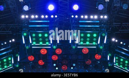 Event stage with colorful spotlights and LED panels illuminating the dark night Stock Photo