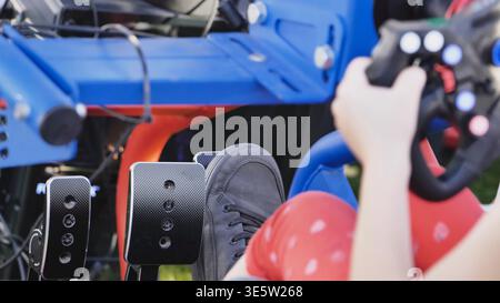 Gamer playing racing video game simulation using steering wheel and pedals Stock Photo