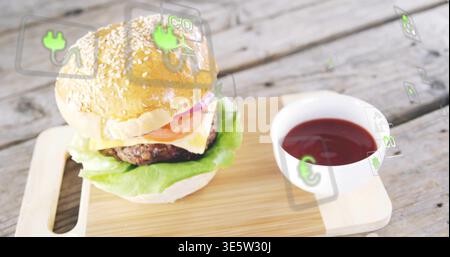 Displaying sesame burger resting on wood board with cheese, ketchup bowl and AR icons, copy space Stock Photo