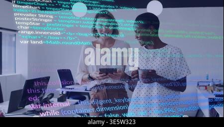 Viewing two women using tablet in office with code overlay, holding mug in work attire Stock Photo