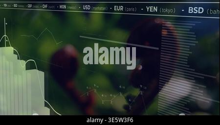Displaying glass panel showing market data at workspace, with charts, currency header, blurred fern Stock Photo
