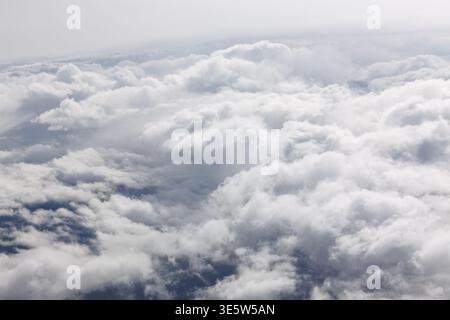 Aerial view of dense white clouds under natural light, soft grey tones and cool color palette, subtle contrast, tranquil sky background, minimal atmos Stock Photo