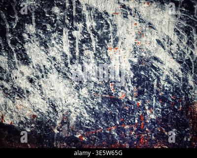 Abstract texture of a weathered metal surface with drips of white paint and spots of orange rust Stock Photo